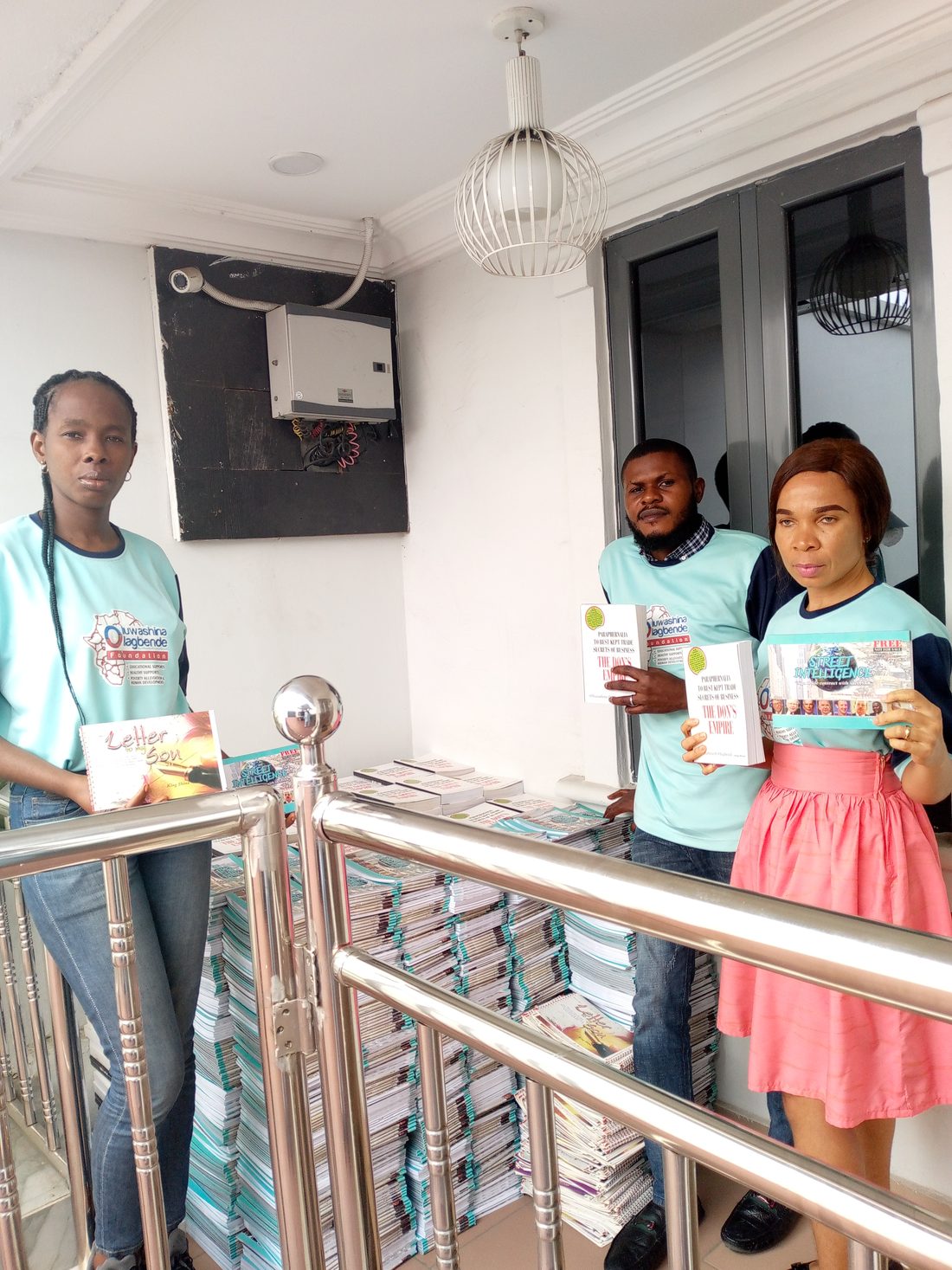 Foundation volunteers with stacks of books and educational materials ready for distribution